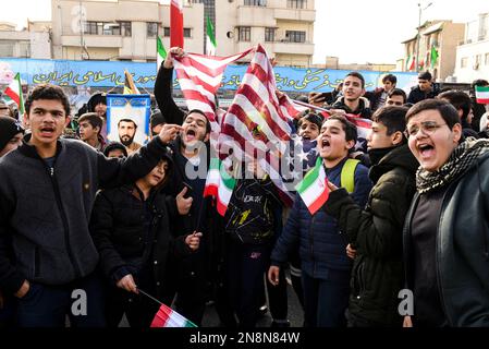 Teheran, Iran. 11. Februar 2023. Der Slogan der jungen Männer spricht Anti-USA während der jährlichen Rallye zum Gedenken an die islamische Revolution im Iran von 1979. (Foto: Sobhan Farajvan/Pacific Press) Kredit: Pacific Press Media Production Corp./Alamy Live News Stockfoto