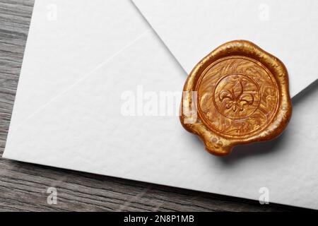 Weißer Umschlag mit Wachsversiegelung auf Holzhintergrund, Nahaufnahme Stockfoto