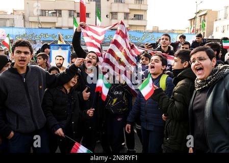 Teheran, Teheran, Iran. 11. Februar 2023. Der Slogan der jungen Männer spricht Anti-USA während der jährlichen Rallye zum Gedenken an die islamische Revolution im Iran von 1979. (Kreditbild: © Sobhan Farajvan/Pacific Press via ZUMA Press Wire) NUR REDAKTIONELLE VERWENDUNG! Nicht für den kommerziellen GEBRAUCH! Stockfoto