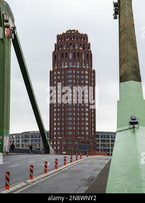 Das Hauptgebäude des Plaza-Turms ist von der Brücke 'Flößerbrücke' aus zu sehen. Hohes Wahrzeichen mit roter Backsteinfassade. Wolkenkratzer im südlichen Teil. Stockfoto