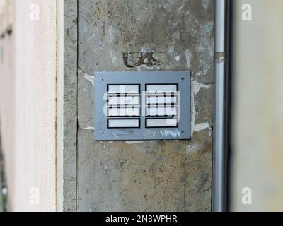 Leeres Namensfeld in einem Apartmenthaus. Leere Vorlage für Namen an einer Türklingel. Wohnhaus mit Regierungswohnungen. Dreckige alte Knöpfe. Stockfoto