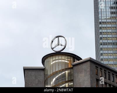 Großes Mercedes-Benz-Emblem in der Innenstadt von Frankfurt. Mercedes-Stern auf dem Dach. Werbung für den deutschen Luxusfahrzeughersteller. Stockfoto