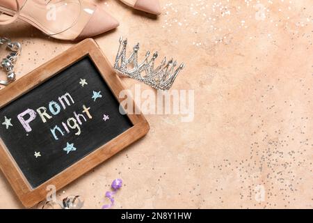 Tafel mit Text FÜR ABSCHLUSSBALL, Diadem, Absätze und Schlangenhaut auf beigefarbenem Hintergrund Stockfoto