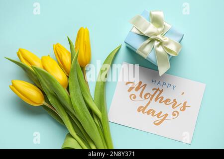 Karte mit Text HAPPY MOTHER's DAY, Geschenk und Tulpen auf mintfarbenem Hintergrund Stockfoto