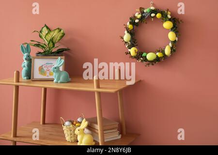Osterkranz hängt an farbigen Wänden im Wohnzimmer Stockfoto