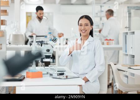 Es war ein erfolgreicher Tag der Probenahme, Tests und Aufzeichnung der Ergebnisse. Porträt eines jungen Wissenschaftlers, der Daumen nach oben zeigt, während er im Labor arbeitet. Stockfoto