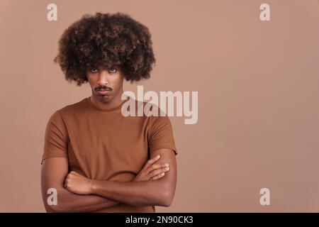 Ein afrikanischer Mann, der die Arme mit einem wütenden Ausdruck überquert Stockfoto