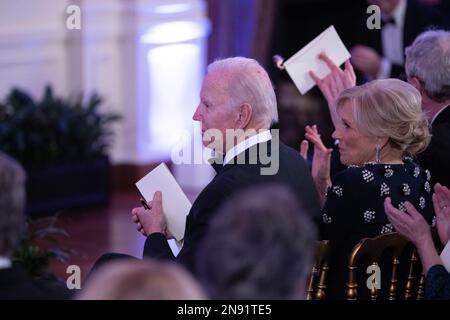 US-Präsident Joe Biden und First Lady Dr. Jill Biden applaudieren als Sänger und Songwriter Brad Paisley auf einer After-Dinner-Party für Gouverneure und ihre Ehepartner im Weißen Haus während der Wintersitzung der National Governors Association in Washington, DC am 11. Februar 2023. Anmerkung: Das Zimmer war mit magentafarbener Beleuchtung beleuchtet. Kredit: Chris Kleponis/Pool über CNP/MediaPunch Stockfoto