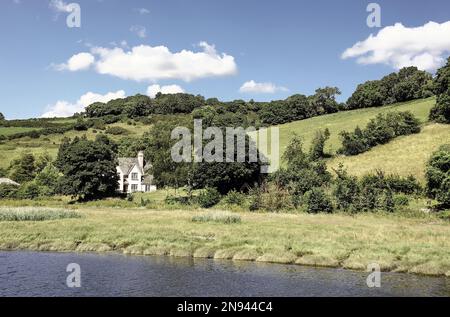 Ein Haus am Ufer des Flusses Tamar   eine Fotografie. Im Sommer 2022 von Plymouth aus auf eine Bootstour auf dem Fluss Tamar. Hitzewelle; Stockfoto