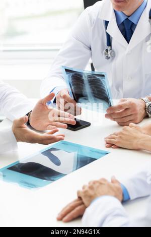 Medizinisches Team prüft Röntgenbefunde, ärztliche Beratung in der Klinik Stockfoto