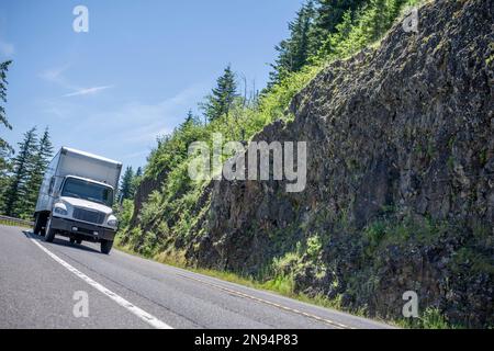 Industriestandard kompaktes kommerzielles Mittellastfahrzeug Weißer Sattelschlepper mit Day Cab Transport von Fracht im Kastenanhänger Fahren auf der Wicklungshalterung Stockfoto