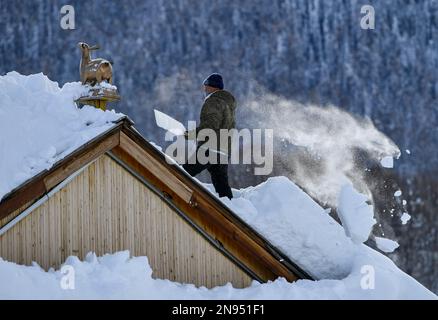 (230212) -- URUMQI, 12. Februar 2023 (Xinhua) -- Ein Dorfbewohner entfernt Schnee auf dem Dach im Dorf Hemu im Altay-Gebirge im Nordwesten Chinas Autonome Region Xinjiang Uygur, 14. Januar 2023. Xinjiang, das über günstige natürliche Bedingungen und mehrere erstklassige Skigebiete verfügt, hat die Hauptrolle in der boomenden Industrie übernommen und ist eines der beliebtesten Wintertouristenziele des Landes. (Xinhua/Hu Huhu) Stockfoto