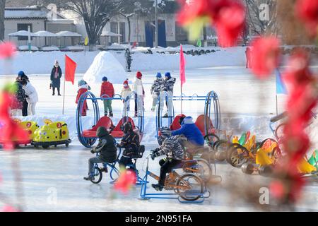 (230212) -- URUMQI, 12. Februar 2023 (Xinhua) -- Kinder spielen auf einer Eislaufbahn eines Parks in Urumqi, Nordwestchina, Uygur Autonomous Region Xinjiang, 15. Januar 2023. Xinjiang, das über günstige natürliche Bedingungen und mehrere erstklassige Skigebiete verfügt, hat die Hauptrolle in der boomenden Industrie übernommen und ist eines der beliebtesten Wintertouristenziele des Landes. (Xinhua/Wang Fei) Stockfoto