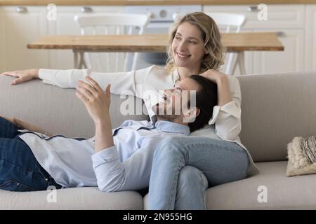 Glückliches junges Paar, das sich zu Hause auf dem Sofa ruht Stockfoto