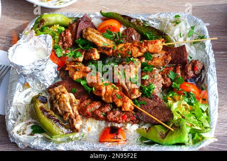 Auswahl an verschiedenen gegrillten Fleischsorten. Kebap-Hühnchen, Fleischbällchen, gegrilltes Gemüse und Reis Stockfoto