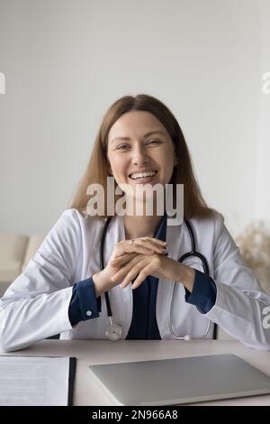 Glückliche, schöne Praktizierende, junge Frau, die im Amt posiert Stockfoto