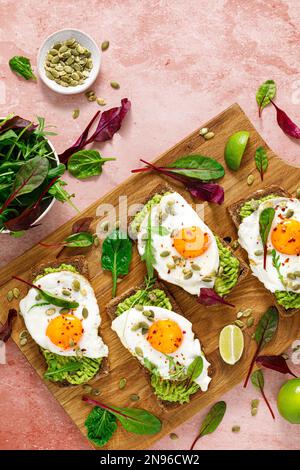 Ei- und Avocado-Toast, Sandwiches mit Eiern und frischem Gemüse. Gesunde Ernährung. Draufsicht Stockfoto