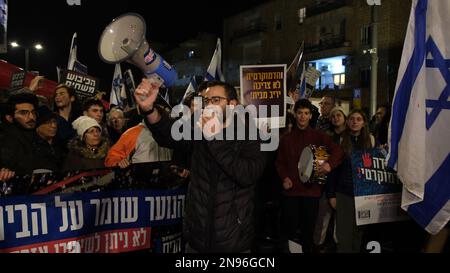 JERUSALEM, ISRAEL - FEBRUAR 11: Demonstranten halten israelische Flaggen und singen während einer Demonstration gegen Israels neuen Plan des Justizsystems, der darauf abzielt, den Obersten Gerichtshof des Landes außerhalb der Residenz des Präsidenten am 11. Februar 2023 in Jerusalem, Israel, zu schwächen. Zehntausende treffen sich in der sechsten Woche in Folge in Israel gegen die weitreichende und umstrittene Reform des israelischen Rechtssystems. Kredit: Eddie Gerald/Alamy Live News Stockfoto