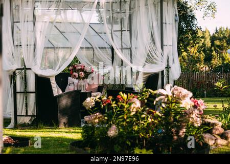 Gartenlaube im Hinterhof, überdachter Zelt, Lounge, Entspannungsbereich im august, schwedischer Garten Stockfoto