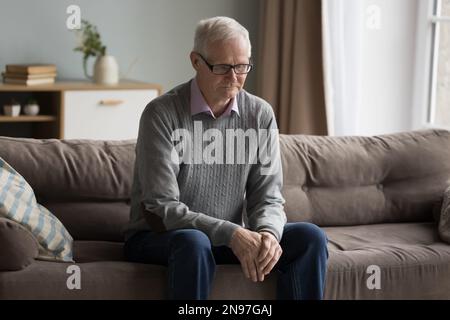 Trauriger depressiver alter Mann, der sich verloren fühlt, einsam zu Hause Stockfoto