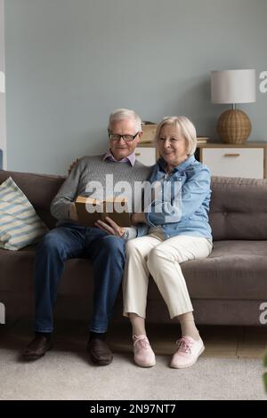 Glücklicher Rentner, Ehemann und Ehefrau, die zu Hause ein Buch lesen Stockfoto