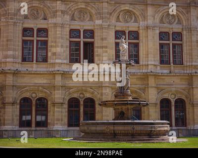 Schöner Opernbrunnen bedeutet unter der krönenden Allegorie der Musik. Die Wiener Staatsoper ist das größte Opernhaus in Österreich, eines der wichtigsten Opernzentren der Welt. Stockfoto