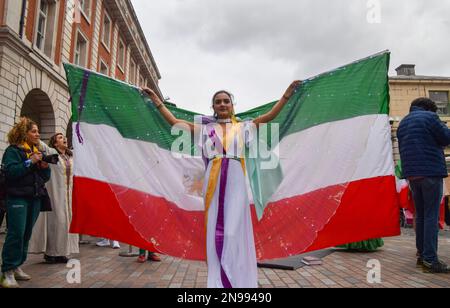 London, Großbritannien. 11. Februar 2023 Ein Demonstrant tritt mit iranischen Flaggen-„Flügeln“ auf. Eine Gruppe von Frauen inszenierte eine Aufführung in Covent Garden, um gegen das iranische Regime und die Hinrichtungen im Iran zu protestieren und um die Freiheit des Iran zu unterstützen. Stockfoto