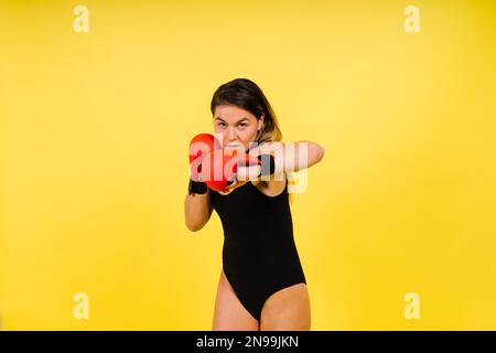 Frau macht High-Kick, Tae-bo. Sportliche Passform für Damen mit perfektem Körperkick und Schlägen mit den Beinen Stockfoto