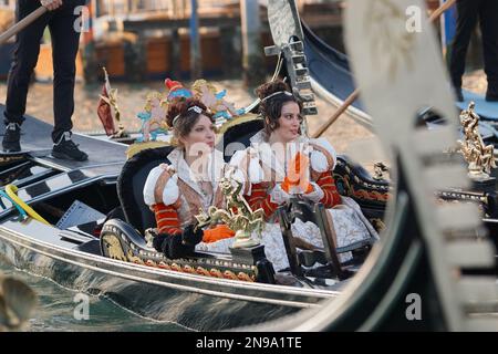 Venedig, Italien. 11. Februar 2023. Zwei junge venezianische Frauen, gekleidet im traditionellen Maria del Carnevale-Kostüm, sitzen in einer Gondel während der Wasserprozession, die die zwölf Maria del Carnevale zur Piazza San Marco brachte, am 11. Februar 2023. © ANDREA MEROLA zwei junge venezianische Frauen, gekleidet im traditionellen Maria del Carnevale-Kostüm, sitzen in einer Gondel während der Wasserprozession, die die zwölf Maria del Carnevale auf die Piazza San Marco brachte, am 11. Februar 2023. © ANDREA MEROLA Credit: Unabhängige Fotoagentur/Alamy Live News Stockfoto