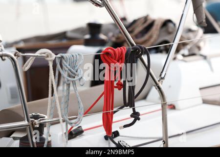 Nautische Seile auf Deck. Winde und nautische Seile auf einem Segelboot. Details zur Segelausrüstung auf dem Boot. Nahaufnahme des Seilknotens, Seemannsknoten Stockfoto