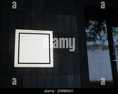 Quadratischer Rahmen auf einer Lichtkastenbeschilderung vor dem Café, dem Einzelhandel, dem Geschäft in der Nähe der Glastür am Eingang. Quadratisches Lichtkastenschild auf Holz w Stockfoto