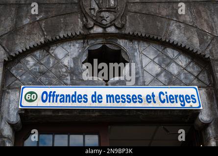 Lourdes, Frankreich - 28. August 2021: Messe- und Kerzenangebote - unterschreiben Sie über dem Büro für Spenden zur Abholung Stockfoto