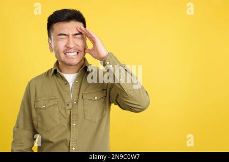 Ein chinesischer Mann, der Gesten macht, dass er etwas vergisst Stockfoto