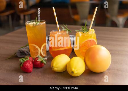 Fruchtgetränk, hausgemachte Limonade oder Sangria mit Zitrusfrüchten und Beeren auf Holzhintergrund, erfrischender Cocktail für heiße Sommertage Stockfoto