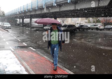 Teheran, Teheran, Iran. 12. Februar 2023. Am 12. Februar 2023 geht ein iranischer Mann während des Schneefalls in der Innenstadt von Teheran, Iran, auf einer Straße entlang. Der seltene Schneefall und das kalte Wetter, die zu einem Mangel an Erdgas für Haushalte und Fabriken geführt hatten, haben die Regierung auch gezwungen, Schulen, Regierungsbüros und private Unternehmen in Teilen des Iran zu schließen. (Kreditbild: © RouzbritFouladi/ZUMA Press Wire) NUR REDAKTIONELLE VERWENDUNG! Nicht für den kommerziellen GEBRAUCH! Kredit: ZUMA Press, Inc./Alamy Live News Kredit: ZUMA Press, Inc./Alamy Live News Stockfoto