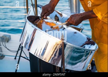 Nahaufnahme eines Musikers aus Jamaika, der auf dem offenen Deck eines Touristenboots in Key West, Florida, Stahlpfanntrommeln spielt. Stockfoto