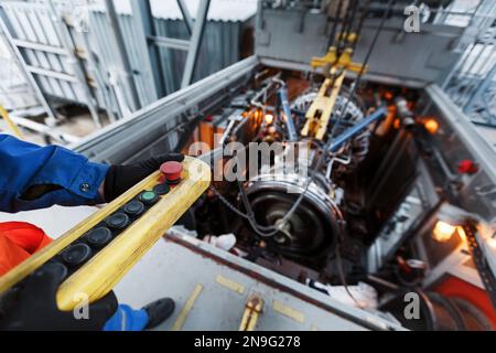 Der Motor eines Gasturbinenkompressors hängt während der Installation in einem Modul zur Stromerzeugung an einem Kran Stockfoto