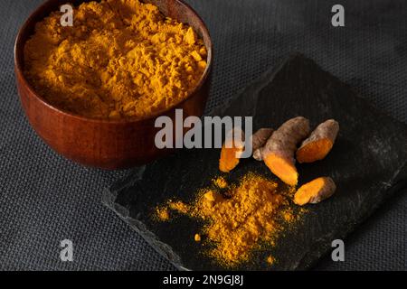 Kurkumwurzeln und -Pulver. Gesundes Gewürzkonzept Stockfoto