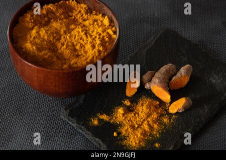 Kurkumwurzeln und -Pulver. Gesundes Gewürzkonzept Stockfoto
