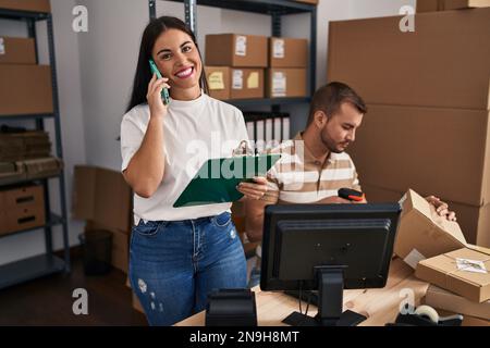 Männer und Frauen, die im Geschäft mit dem Smartphone sprechen und das Etikett mit einem Barcode-Lesegerät scannen Stockfoto