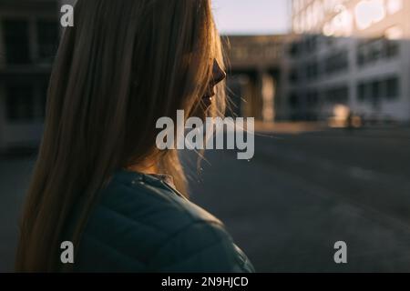 Blondes Mädchenporträt auf dunkler Straßenzusammenstellung Stockfoto