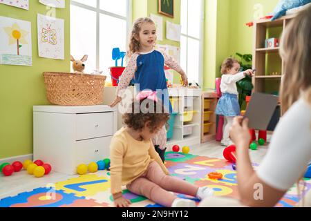 Eine Gruppe von Kindern, die Unterricht haben, sitzt auf dem Boden im Kindergarten Stockfoto