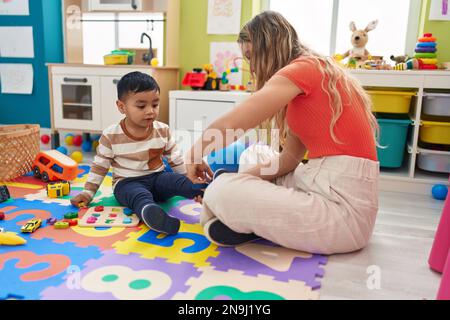 Lehrer und Kleinkinder-Bindeschuhe im Kindergarten Stockfoto