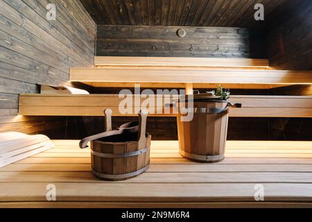 Moderne Innenausstattung der Spa-Hütte aus Holz. Blick auf den leeren finnischen Saunaraum mit Trockendampf. Neu und frisch Stockfoto
