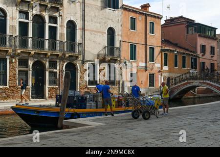 Entladen von Vorräten von einem Boot auf dem Rio de San Barnaba Kanal im Sestiere von Dorsoduro im Sommer, Venedig, Veneto, Italien Stockfoto