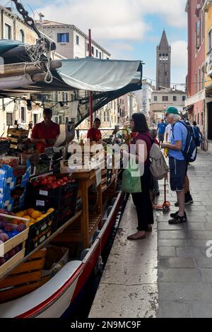 Leute, die im Sommer im Greengrocer Boot am Rio de San Barnaba Kanal in der Sestiere von Dorsoduro einkaufen, Venedig, Veneto, Italien Stockfoto