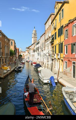 Von oben aus haben Sie einen Blick auf eine Gondel auf dem Kanal Rio de San Barnaba mit dem Glockenturm der Kirche Santa Maria dei Carmini, Venedig, Veneto, Italien Stockfoto