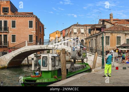 Müllabfuhr in einem Elektroboot, das neben der Brücke Ponte Santa Margarita in Campo San Pantalon, Sestiere von Dorsoduro, Venedig, Italien, festgemacht ist Stockfoto