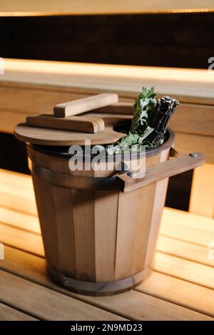 Nahaufnahme verschiedener Saunazubehör in einer Holzsauna. Finnischer Saunaraum mit Trockendampf Stockfoto