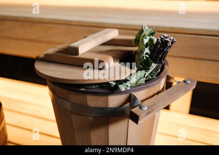 Nahaufnahme verschiedener Saunazubehör in einer Holzsauna. Finnischer Saunaraum mit Trockendampf Stockfoto